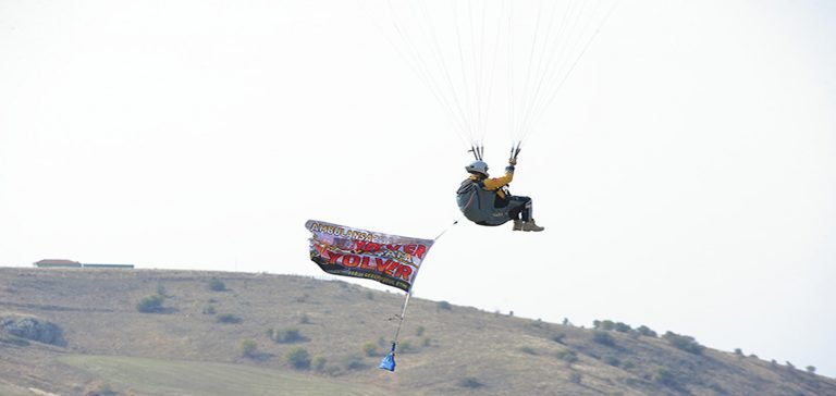 Yamaç paraşütünden açtığı afişle ambulanslara yol istiyor